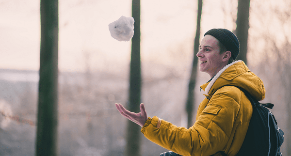 young man catching a snowball
