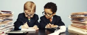 children in professional clothing looking at financial documents